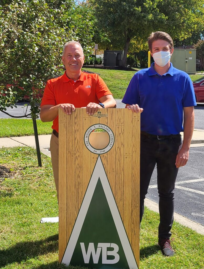 2022 Cornhole tournament winners Richard Feustle and Rian Wamback holding the official WTB cornhole board